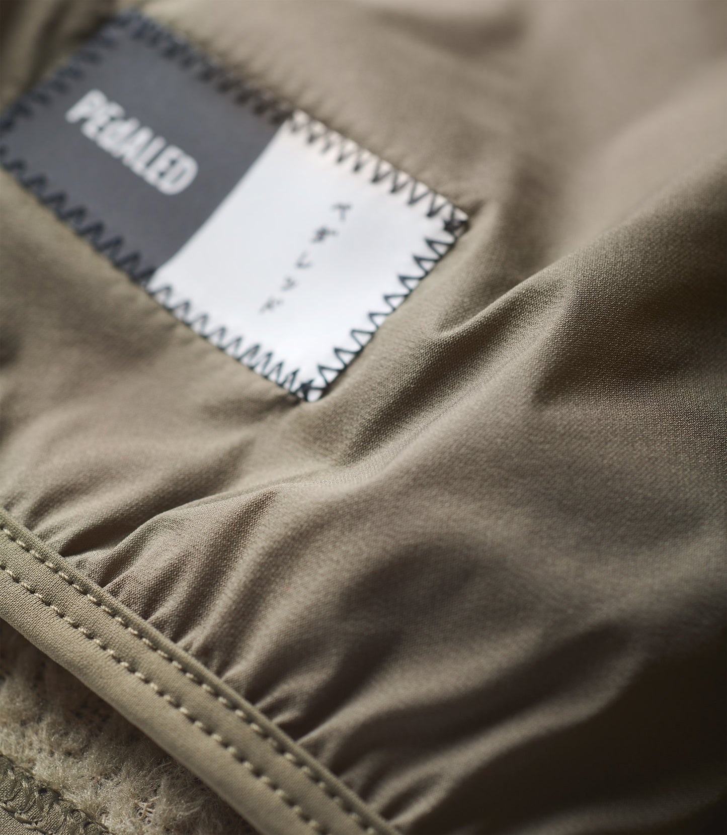 24WANEL11PE_3_cycling neck warmer polartec alpha green element detail pedaled