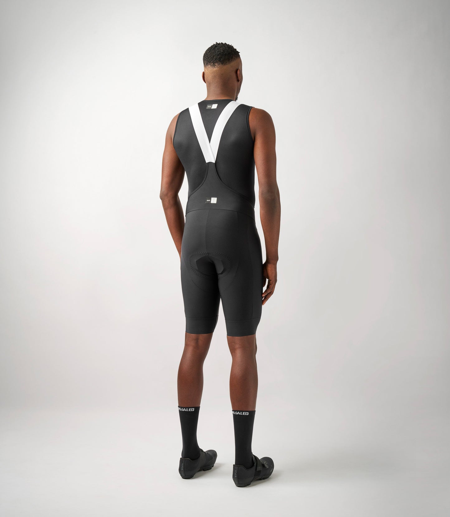 23SBBES00PE_4_men cycling bibshorts essential black total body back pedaled