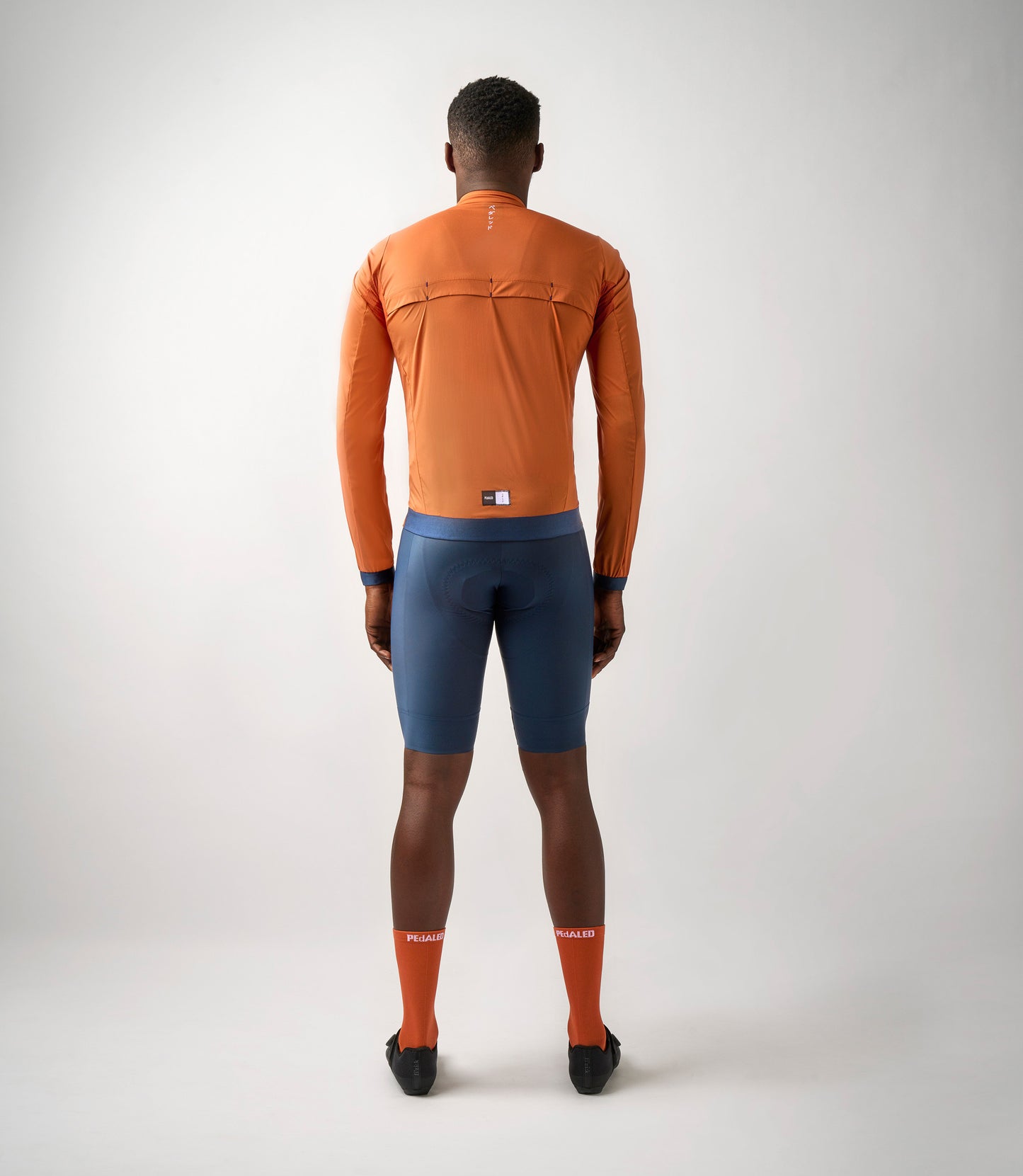 23SJKES0HPE_4_men cycling windproof jacket orange essential total body back pedaled