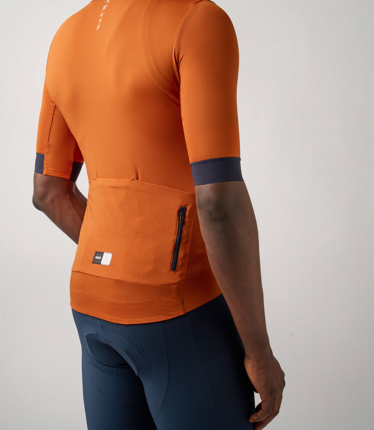 23SJSES0HPE_7_cycling jersey men orange essential back pocket pedaled
