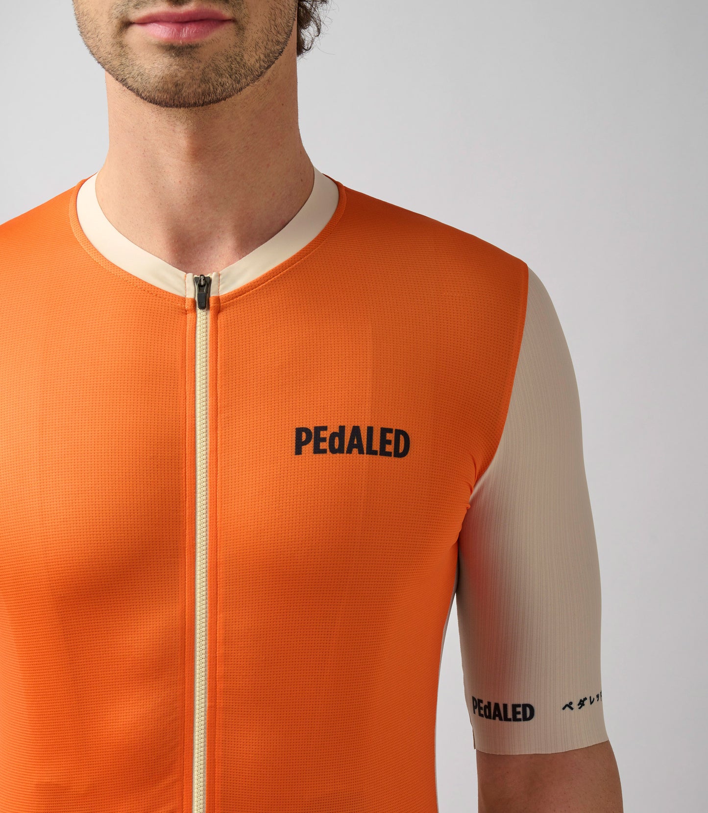 23SJSLO0HPE_5_cycling jersey men orange logo front pedaled