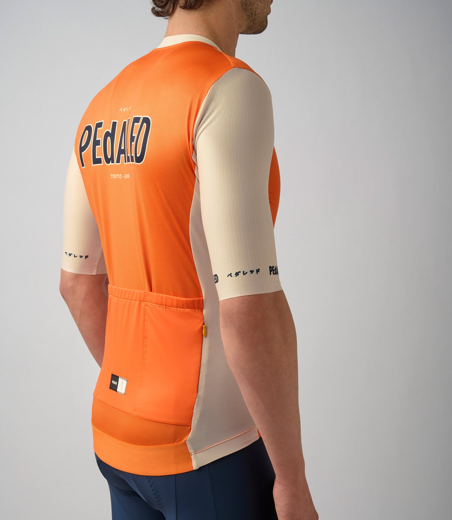 23SJSLO0HPE_7_men cycling jersey orange logo back pocket pedaled