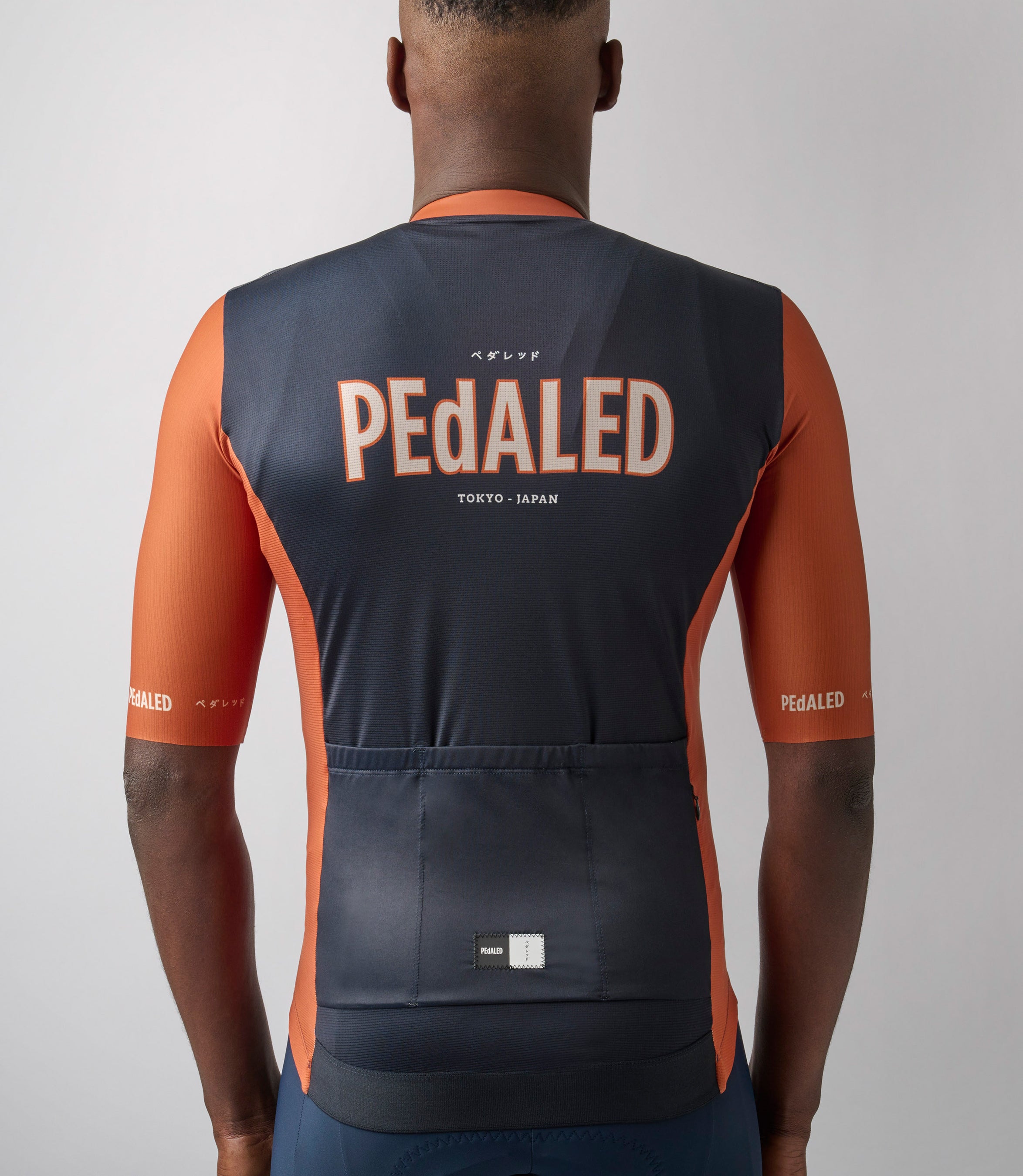23SJSLO74PE_6_men cycling jersey navy logo back neck pedaled