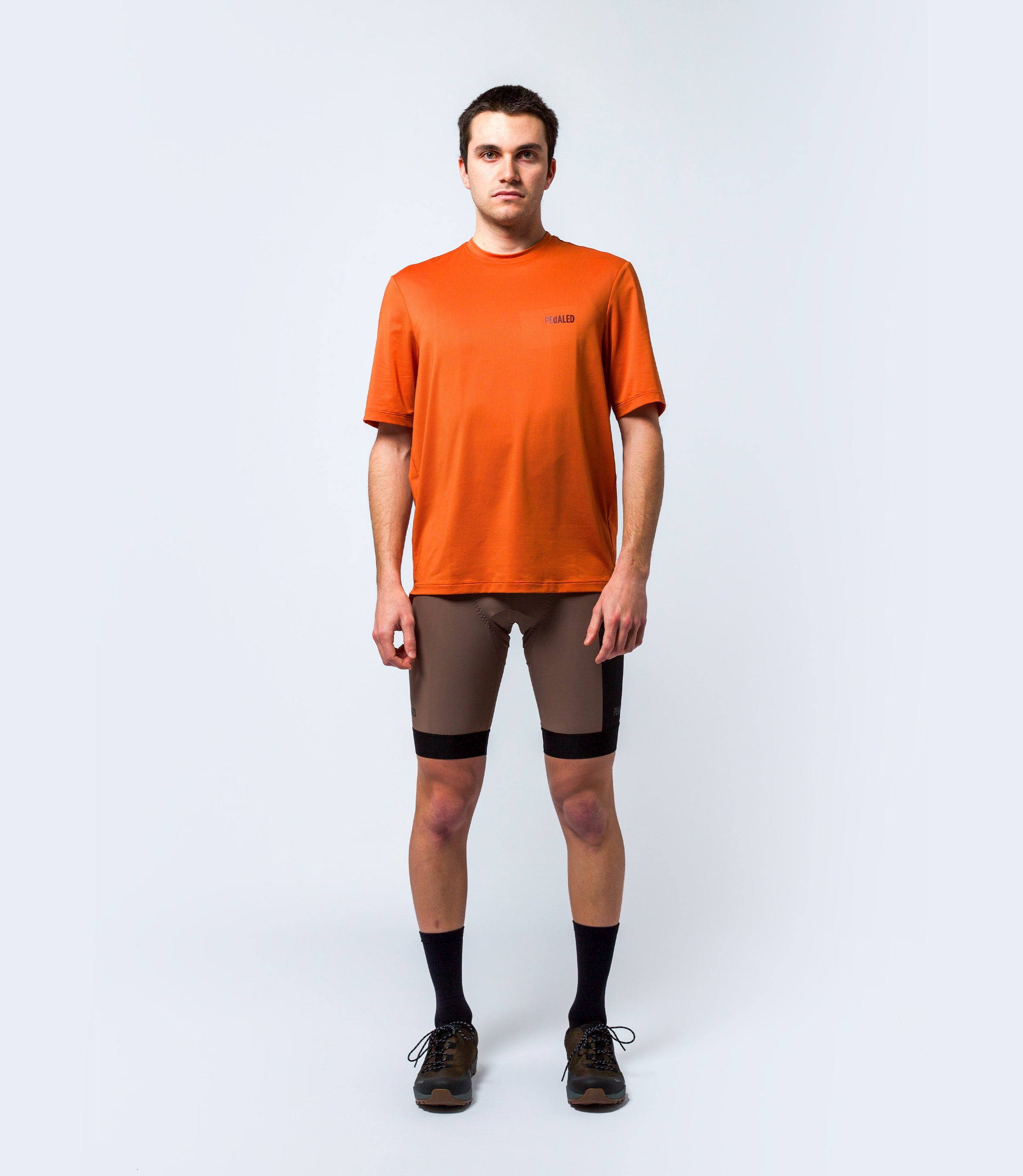 23STSJA0HPE_3_cycling gravel tech tee orange jary total body front pedaled