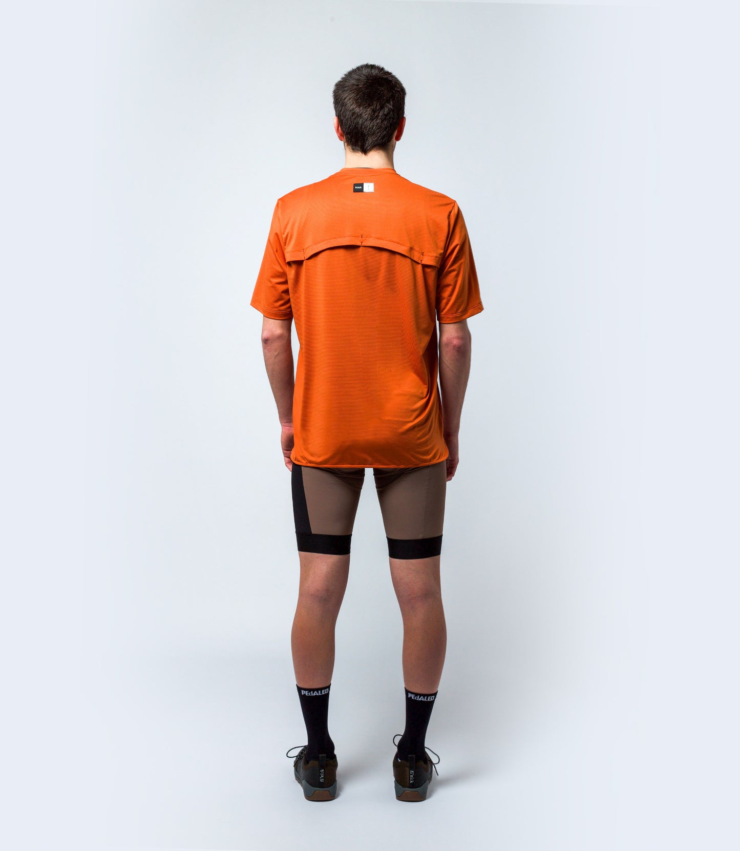 23STSJA0HPE_4_cycling gravel tech tee orange jary total body back pedaled