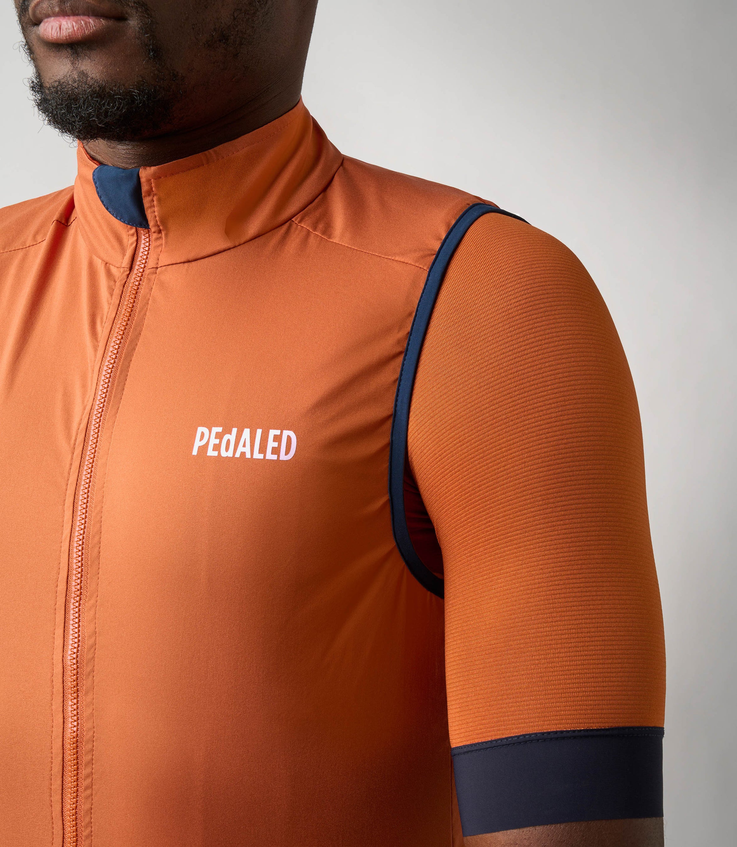 23SVEES0HPE_8_windproof vest men cycling orange essential front logo pedaled