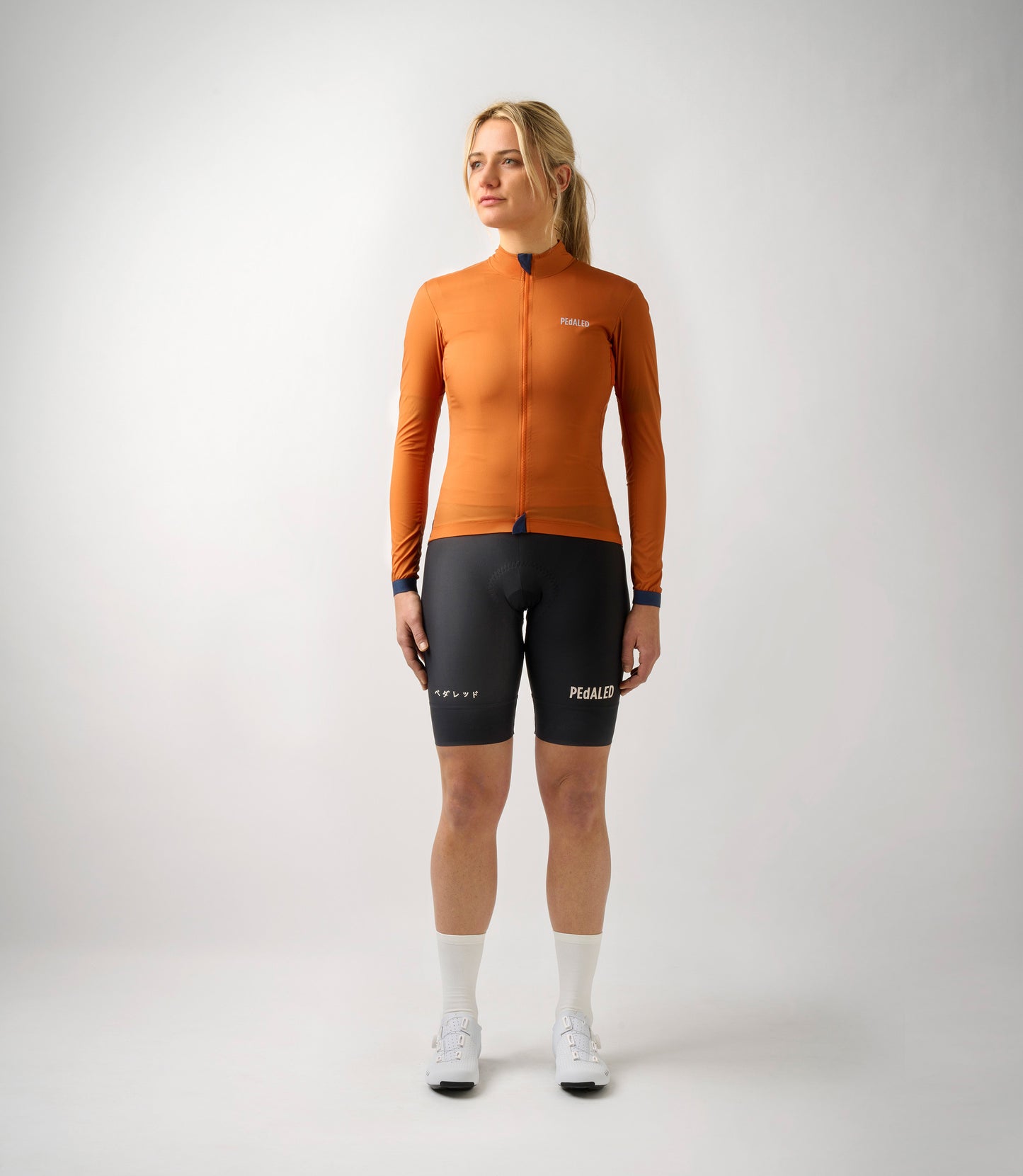 W3SJKES0HPE_3_women cycling windproof jacket orange essential total body front pedaled