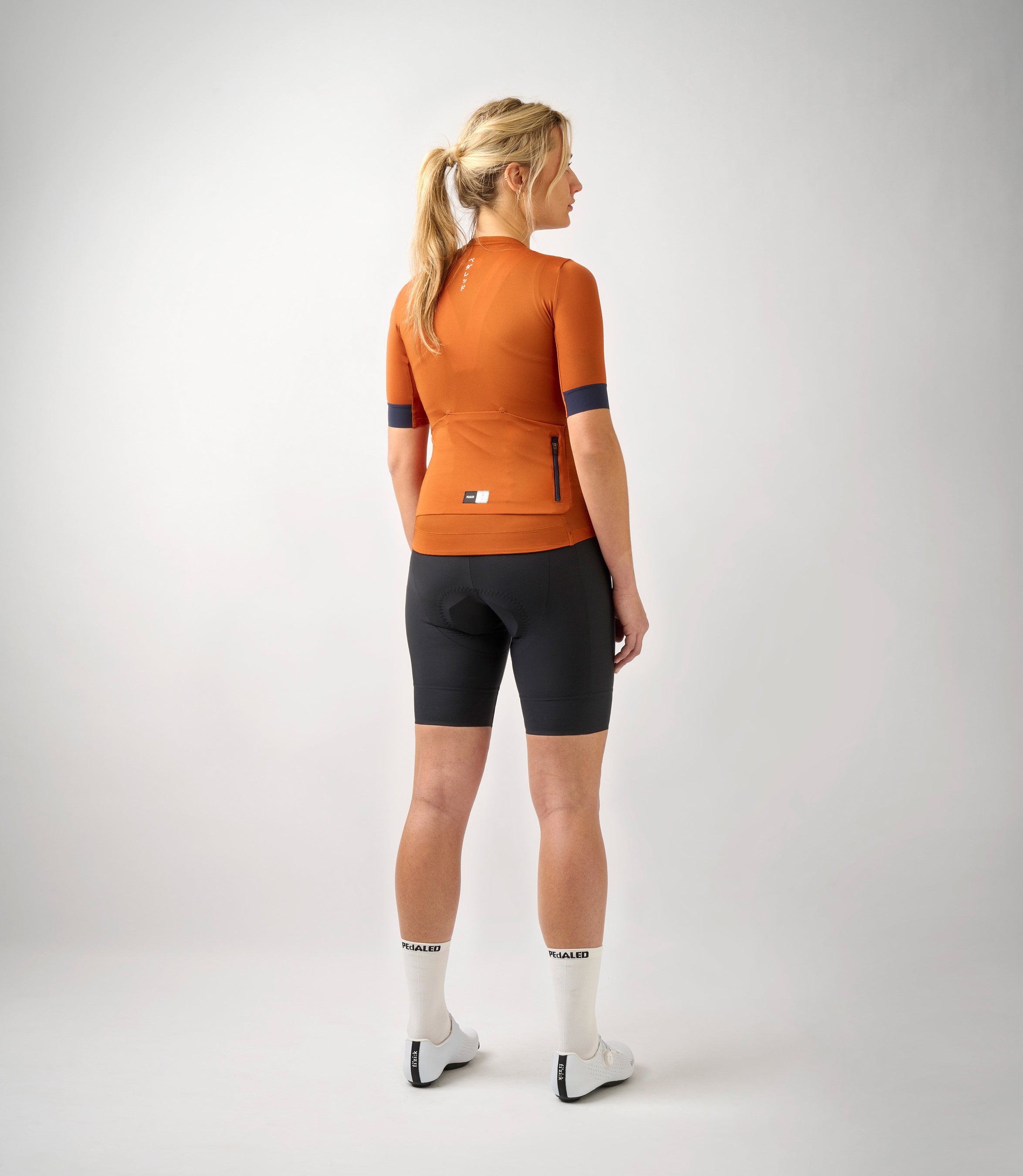 W3SJSES0HPE_4_women cycling jersey essential orange total body back pedaled